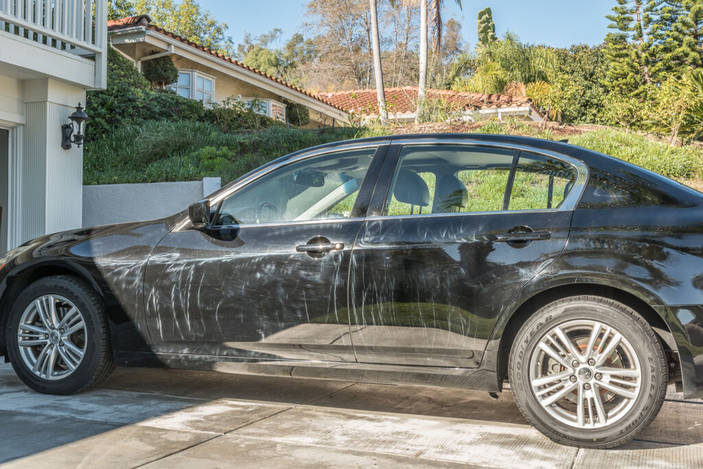 Swirl marks and paint damage caused by improper car washing — before professional correction at OCDetailing