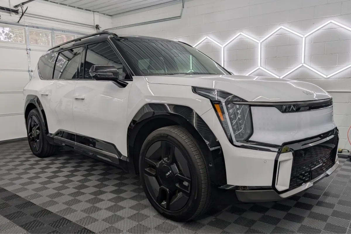 A white Kia SUV inside a detailing studio