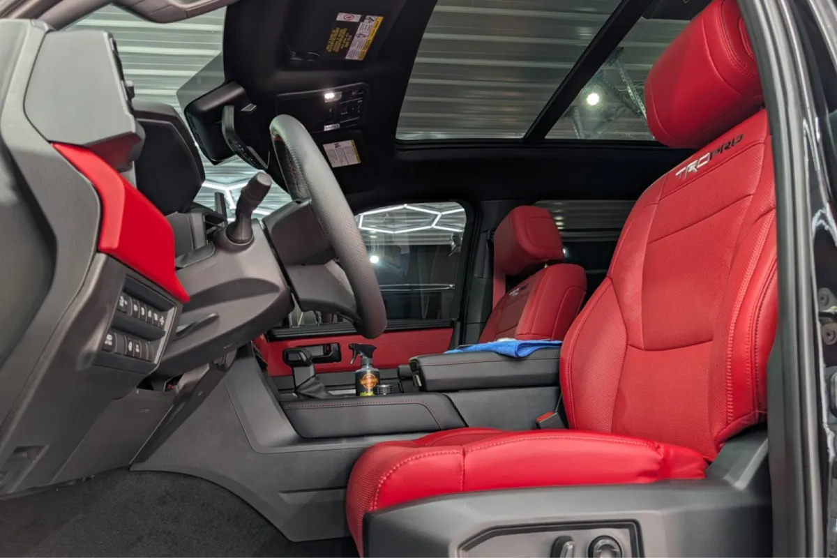 Side view of red leather car interior with center console and panoramic roof