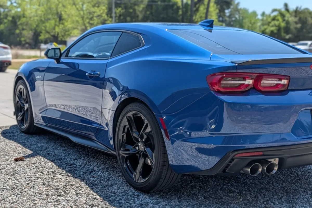 Blue Chevrolet Camaro ZL1 side view with black wheels.
