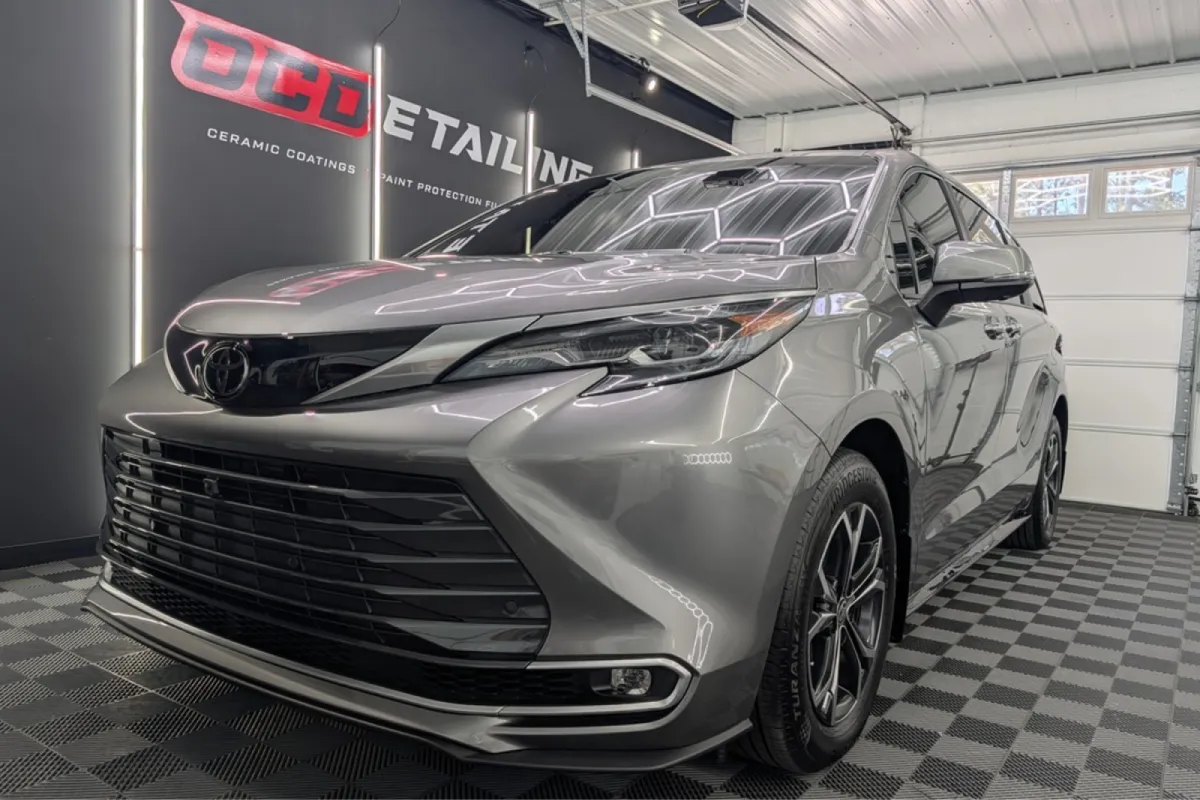 Side view of the silver Toyota Sienna in a garage, showcasing the sleek and glossy appearance.