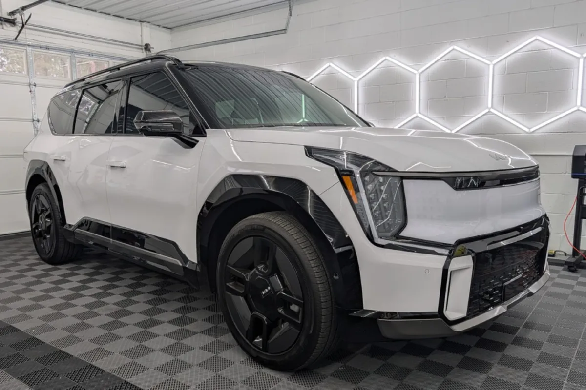 white SUV highlighting its sleek design and blacked-out wheels in a well-lit garage.