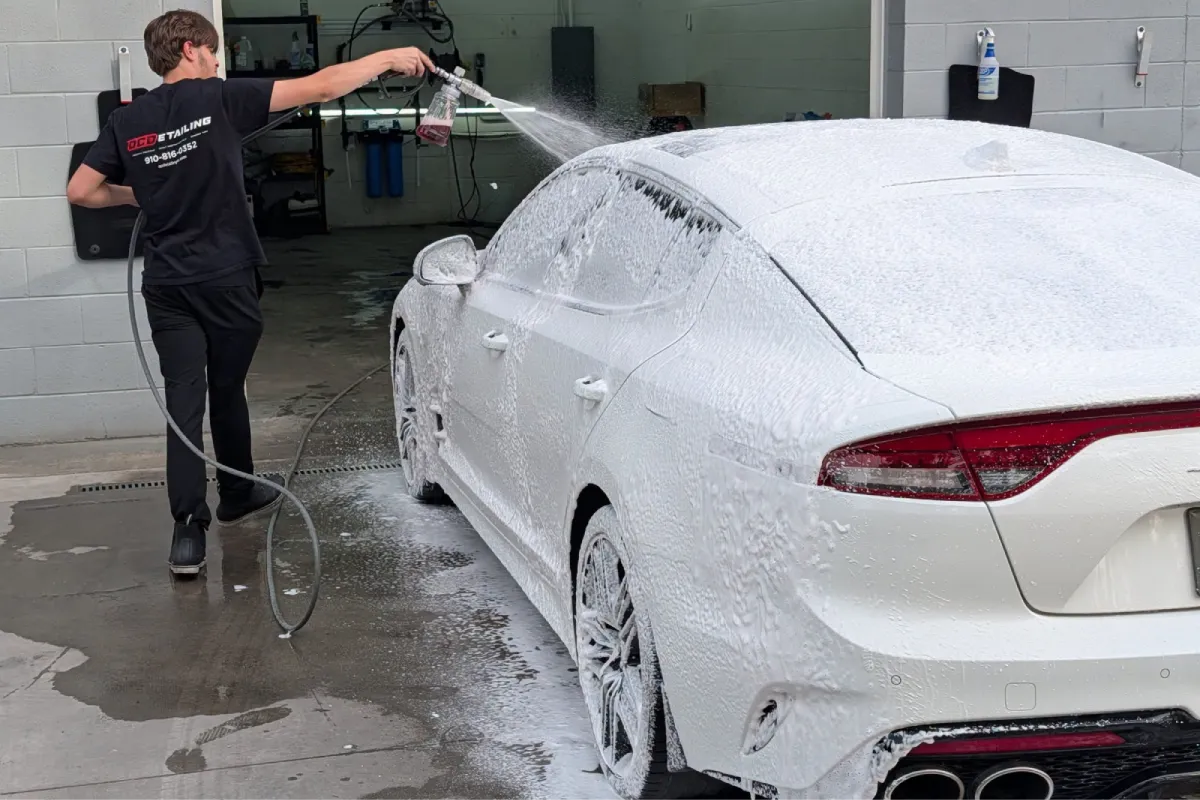 Detailer foam washing a car.