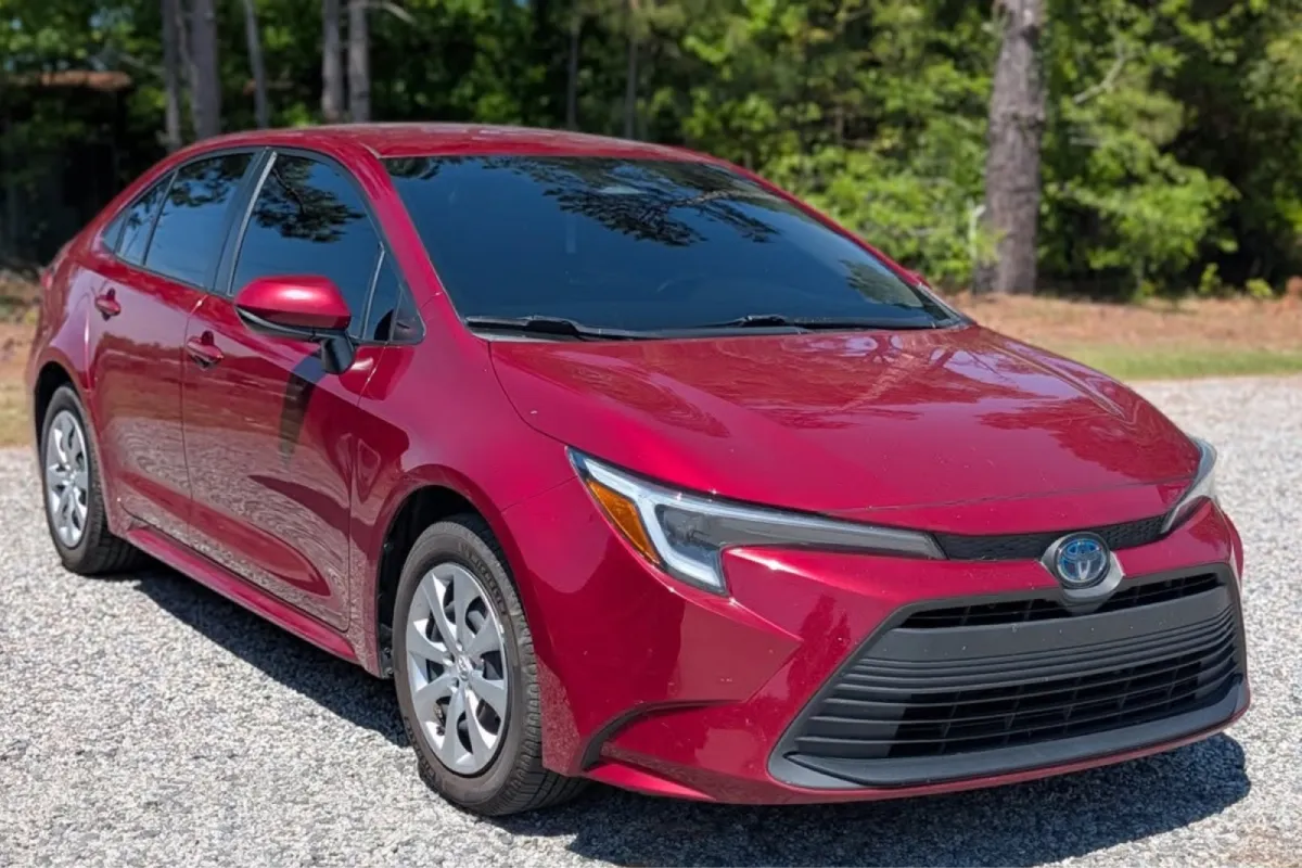 Front side view of a red Toyota Corolla with tinted windows.