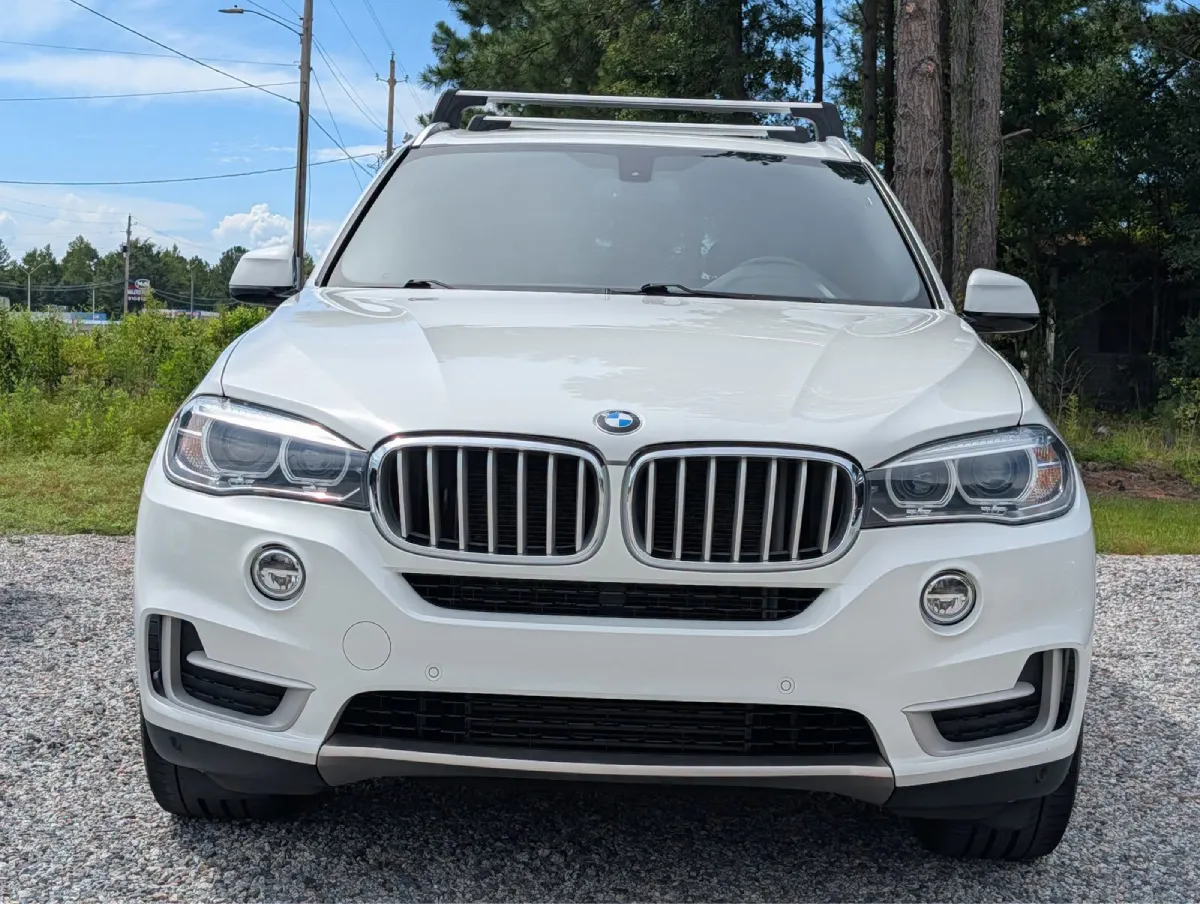 Front view of a white BMW SUV featuring dark window tinting
